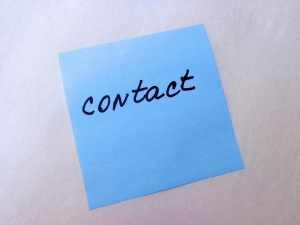 Blue post-it where the word contact is handwritten.